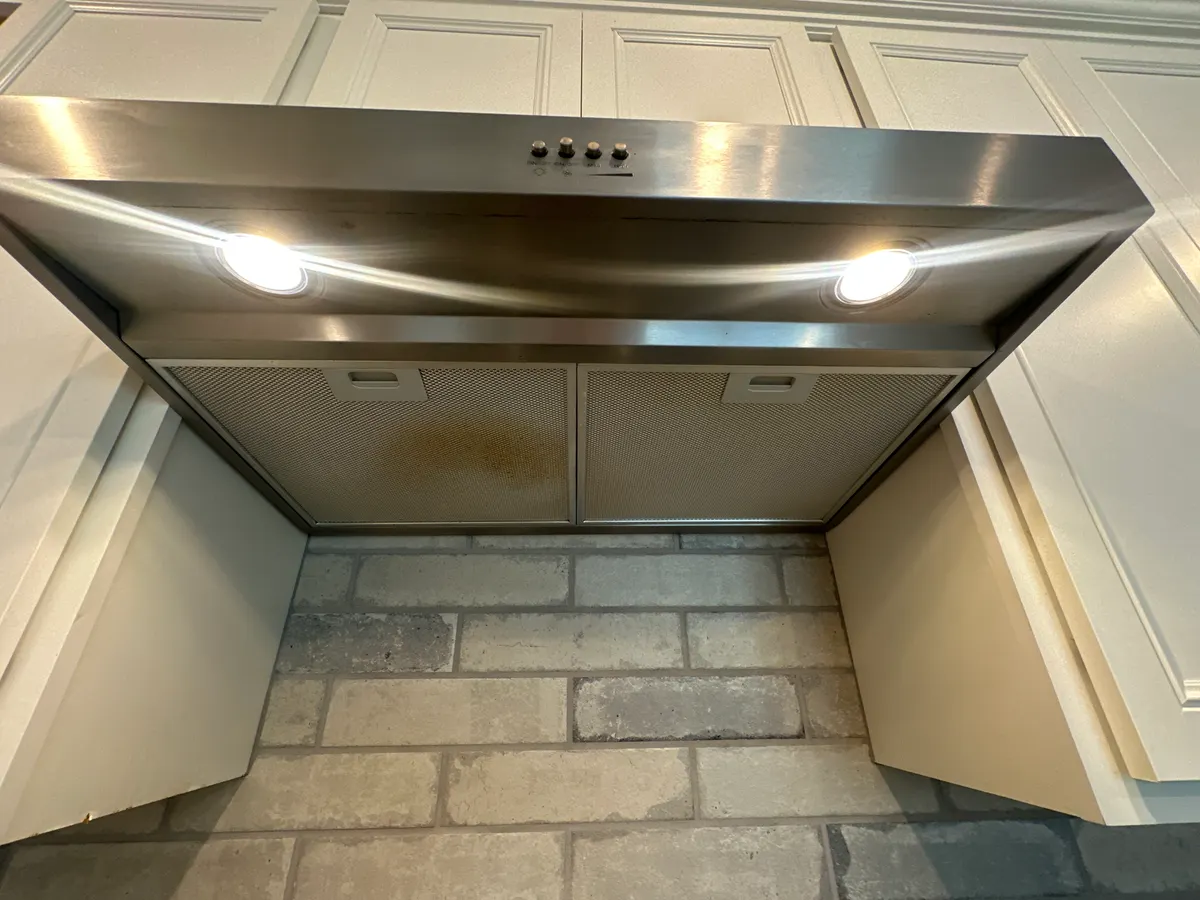 Kitchen range hood before cleaning, with a greasy filter